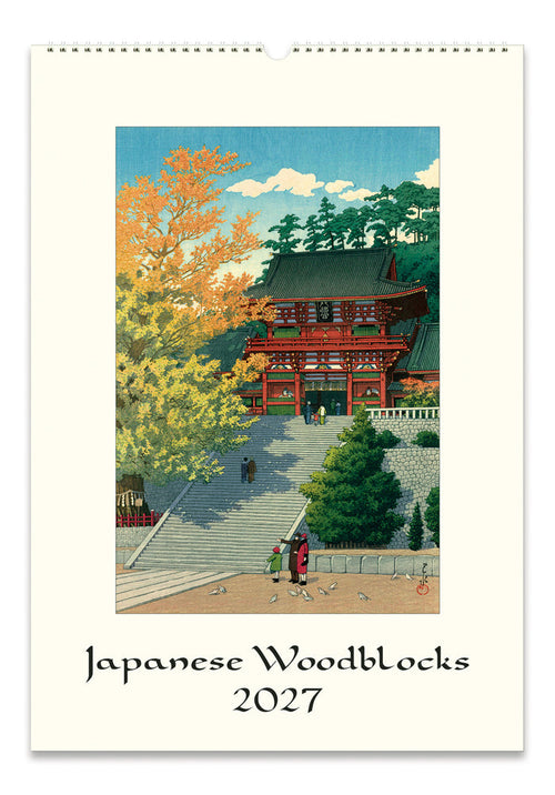 A spiral-bound wall calendar featuring a  Japanese woodblock illustration of a temple courtyard with stairs, trees in autumn colors, and a red building. The text 'Japanese Woodblocks 2027' appears below the artwork on an off-white background.