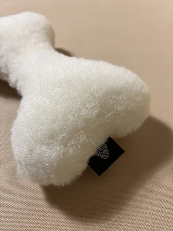 Soft cashmere bone-shaped pet pillow with plush, natural cashmere fabric for comfortable pet rest.