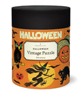 'Halloween Vintage Puzzle' by Cavallini & Co., featuring a black lid and an orange label decorated with classic Halloween illustrations including a witch, cat, owl, and jack-o'-lantern.