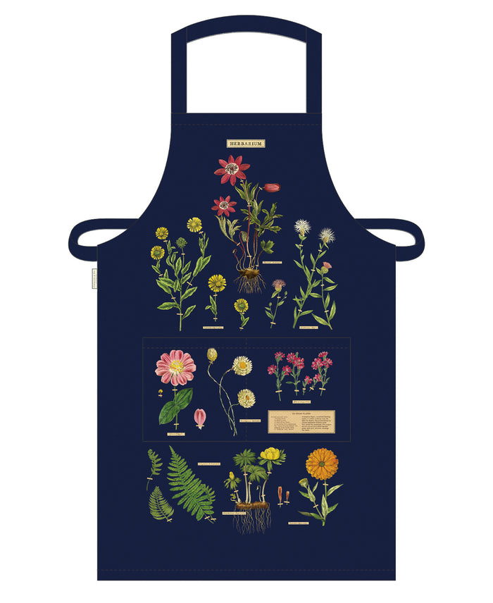 Cavallini & Co. Herbarium Cotton Apron features reproductions of vintage scientific images, complete with scientific names. The detailed images stand out on the dark background.