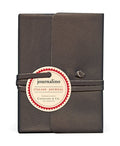 A medium-sized, charcoal-colored leather journal with a leather thong wrap around it, featuring the Cavallini & Co. Journalino label.