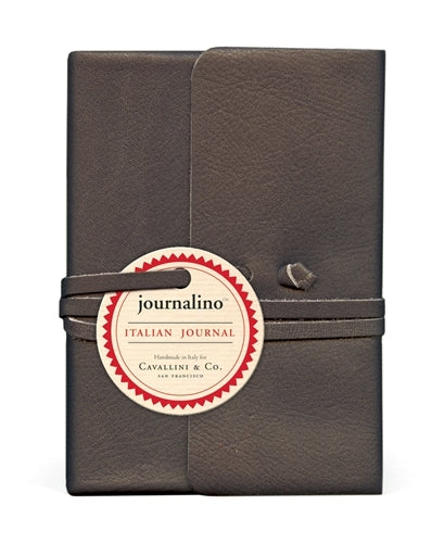 A medium-sized, charcoal-colored leather journal with a leather thong wrap around it, featuring the Cavallini & Co. Journalino label.