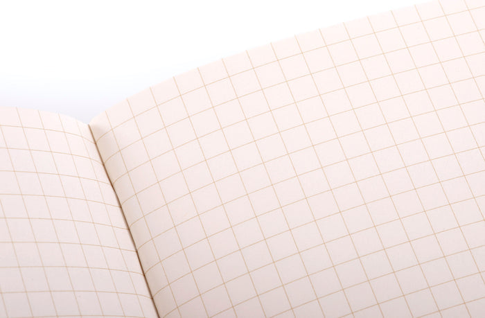 Close-up of a notebook with grid paper on a white background