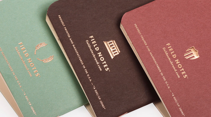 Three Field Notes notebooks in different colors on a white background