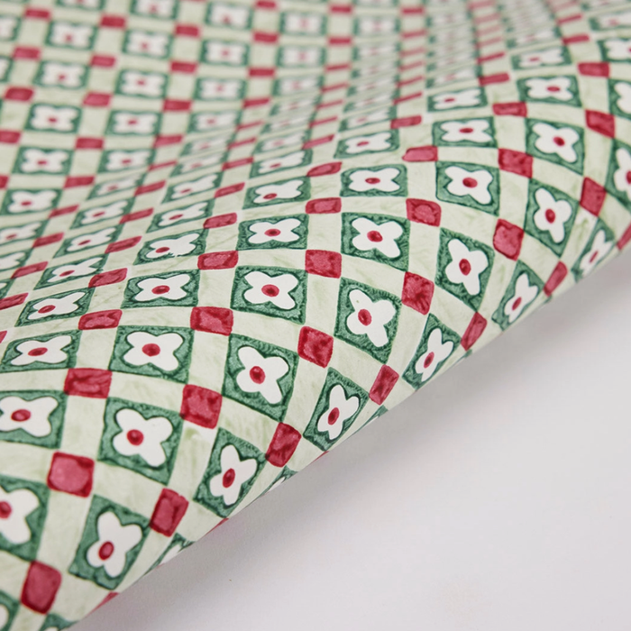 Patterned paper with red, green, and white design on a white background