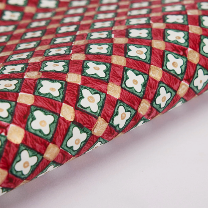Close-up of a red, green and gold checkered paper with floral patterns