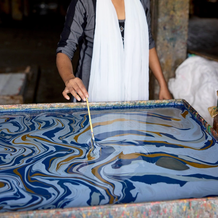 Handmade marbled paper "free spirit" shades of dark blue with gold- marbling in progress