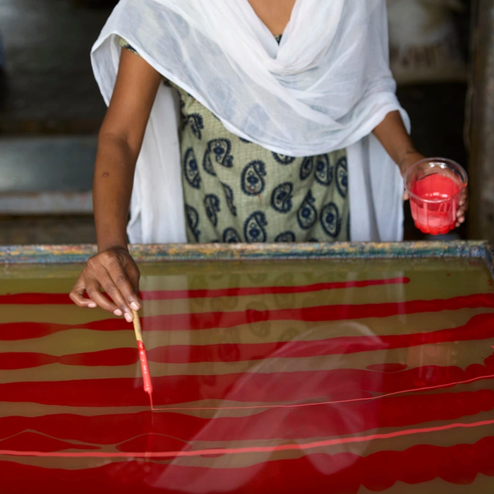 Woman marbling paper - applying coral color