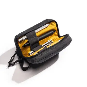 Black pouch with yellow interior containing pens on a white background. Items shown in pouch not included.