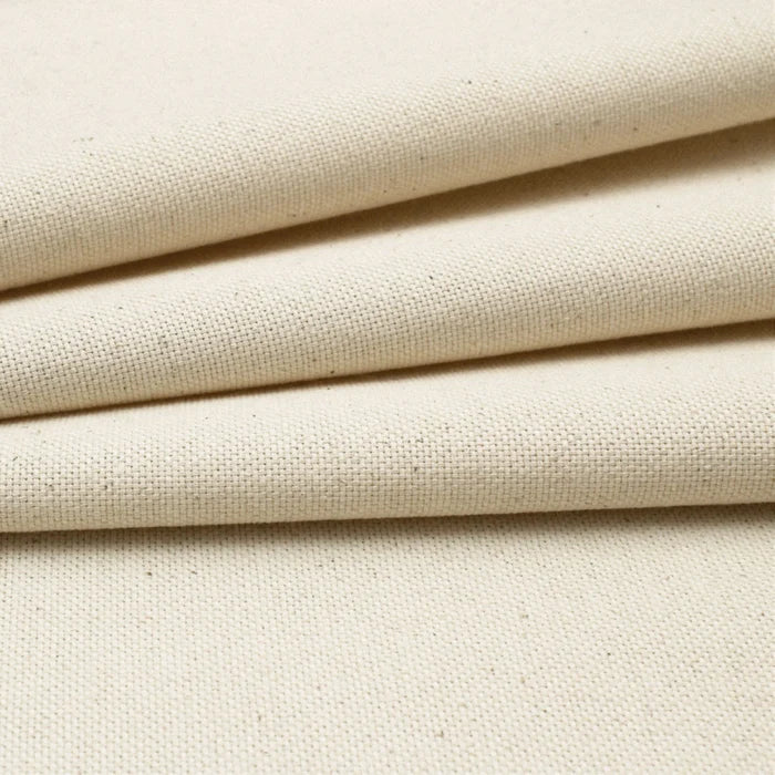 Close-up of cotton canvas fabric with a visible woven texture and subtle warm beige undertones.