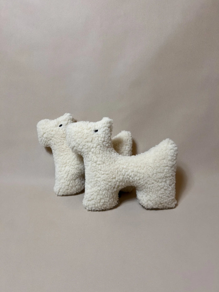 Two small wool plush pet toys featuring a bouclé loop textured material, standing on a neutral beige background.
